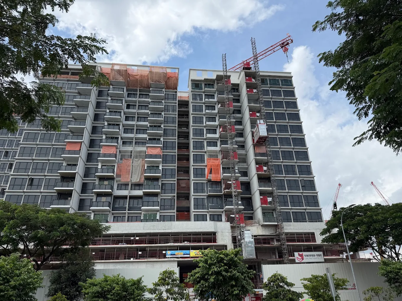 Close construction-stage view of a PARKTOWN Residence residential block with repeated glazed balconies.