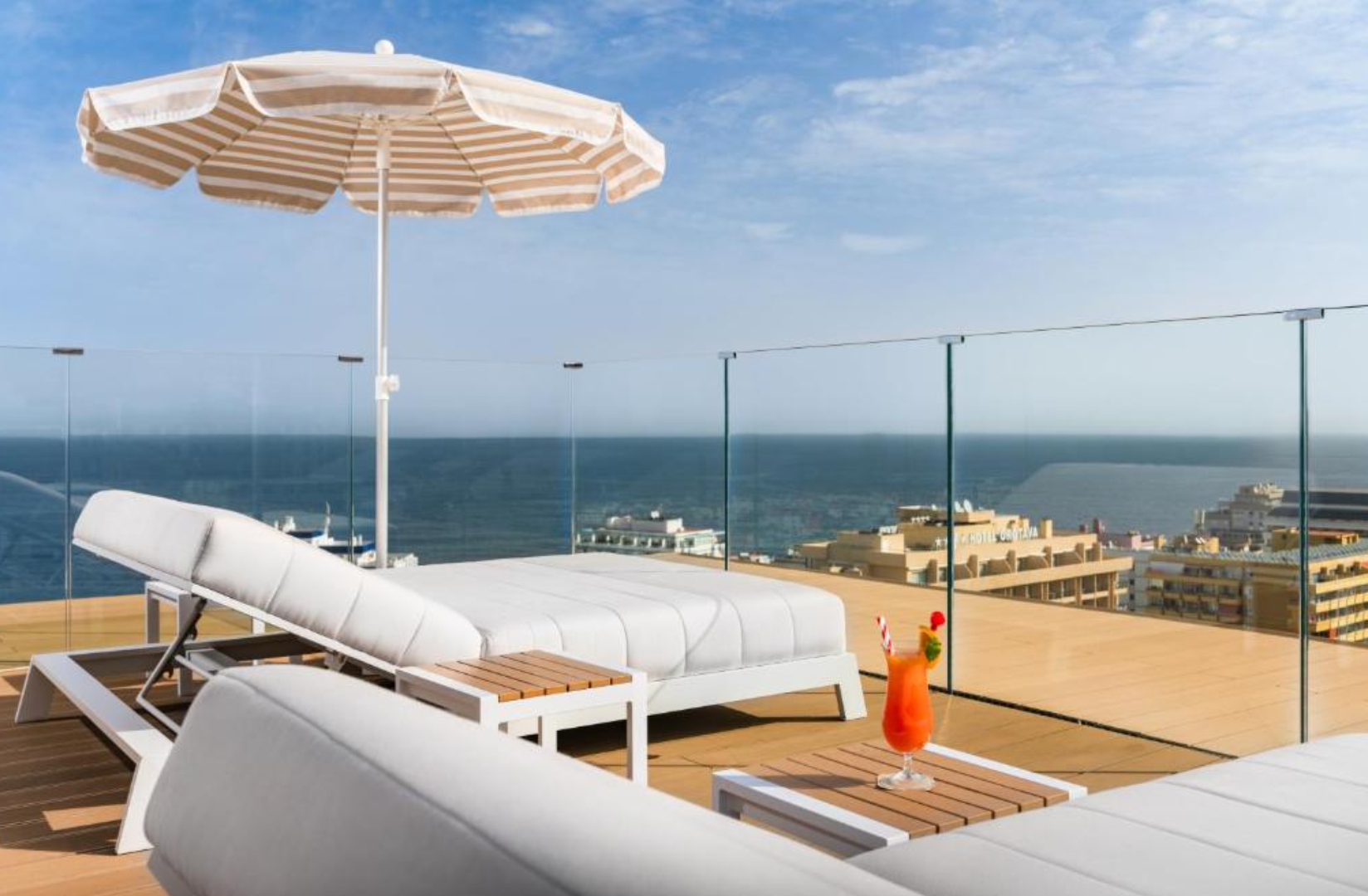 Low-iron glass railing on the completed Hotel Atlantic El Tope rooftop terrace overlooking the Atlantic Ocean.