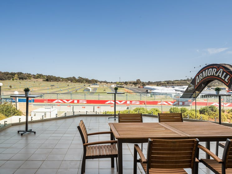 Trackside hotel terrace with transparent glass railing overlooking Conrod Straight at Mount Panorama.